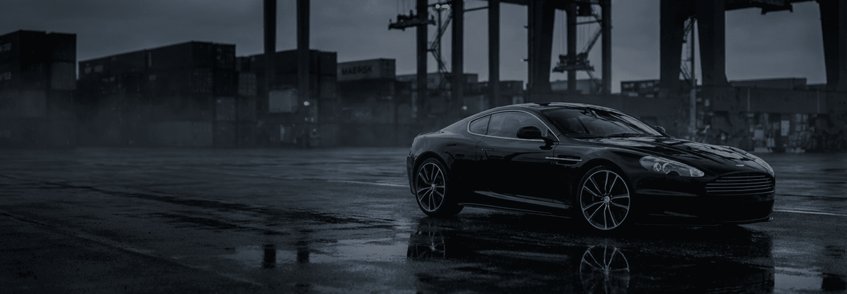 Ocean Trading website hero: a dark sports car on a wet container-port quay at dusk